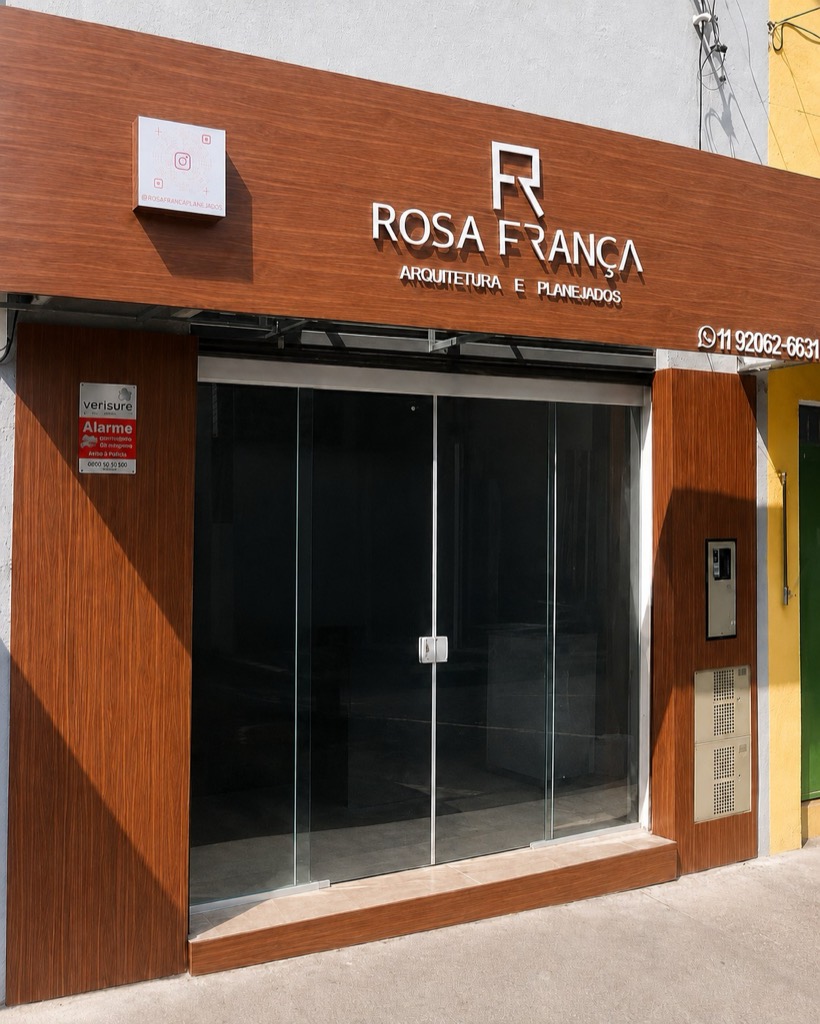 Fachada da loja Rosa França Arquitetura e Planejados, com painel amadeirado e porta de vidro
